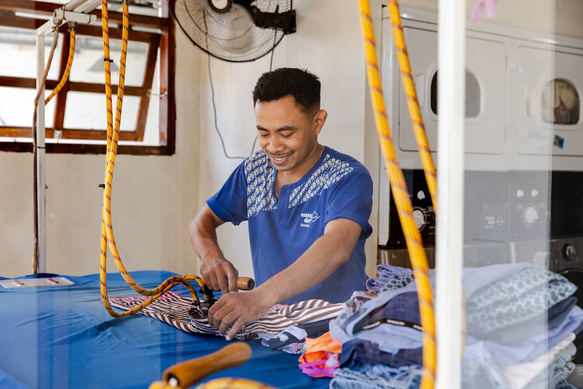 Easy Day Laundry team member hand-ironing clothes at the Seminyak shop in Bali