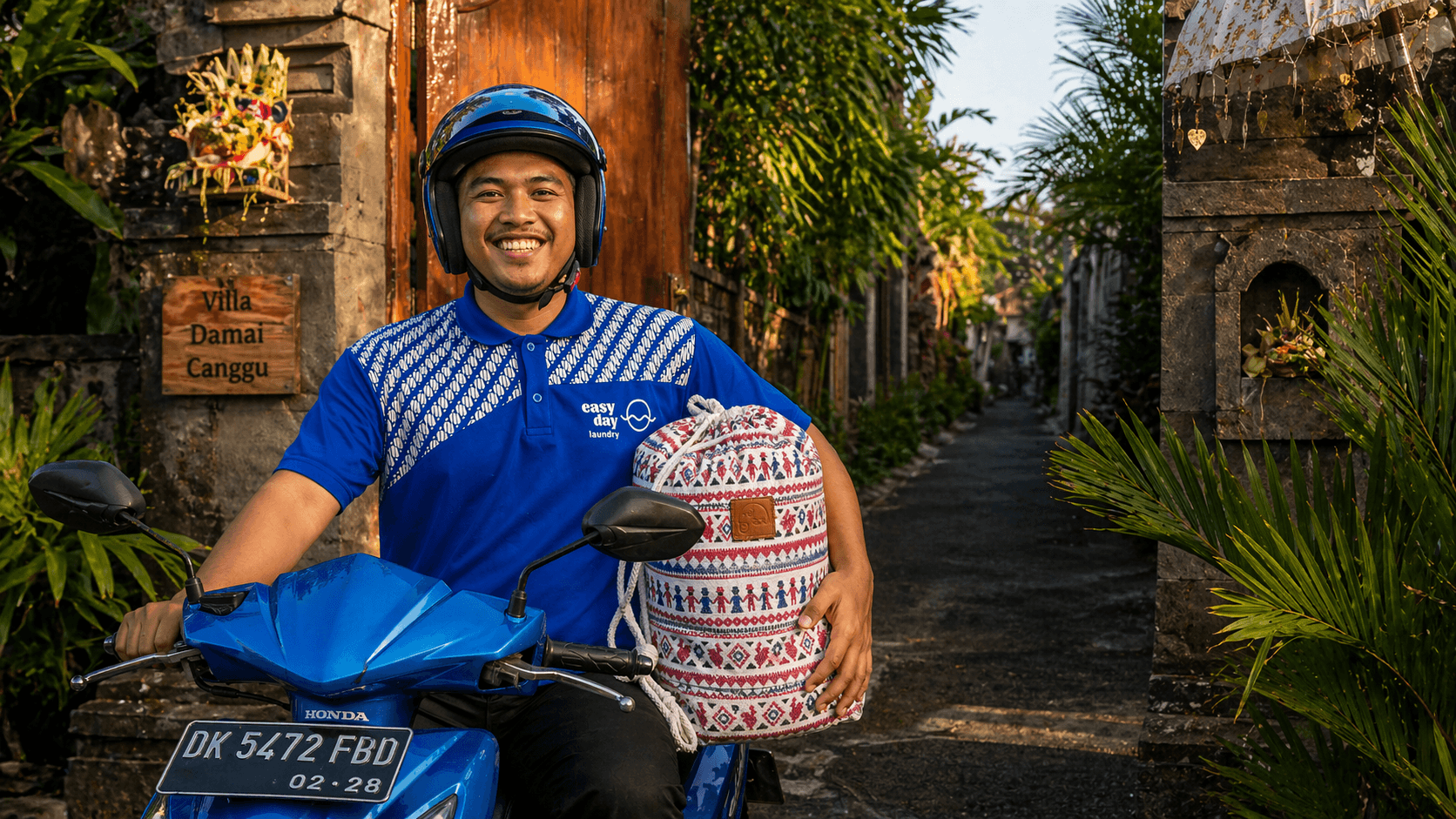 Laundry pickup and delivery service in Canggu with driver collecting a bag from a villa