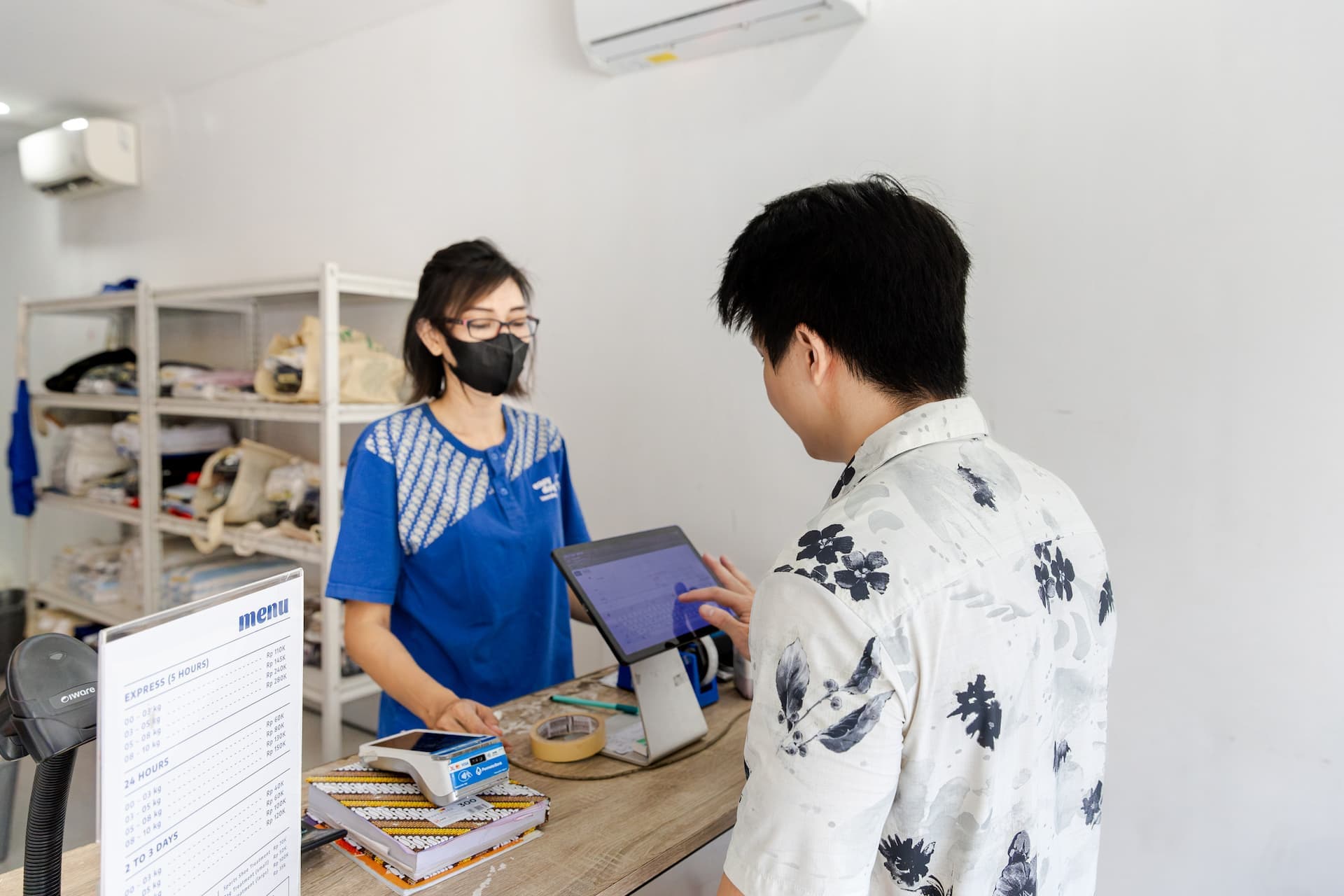 Easy Day Laundry team member helping a customer enter an order on the counter tablet