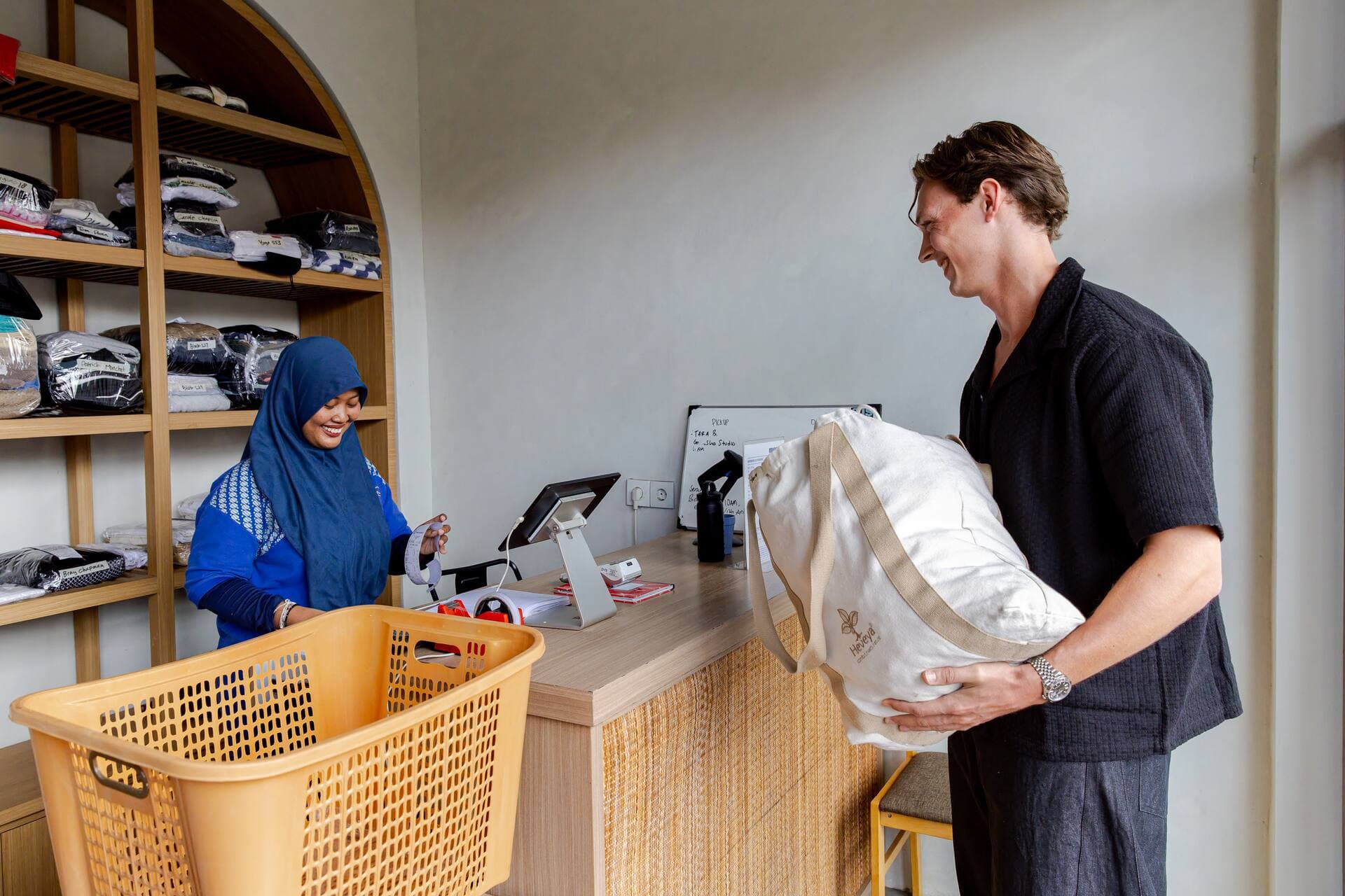 Easy Day Laundry team member checking in a customer's laundry bag at the Pererenan counter