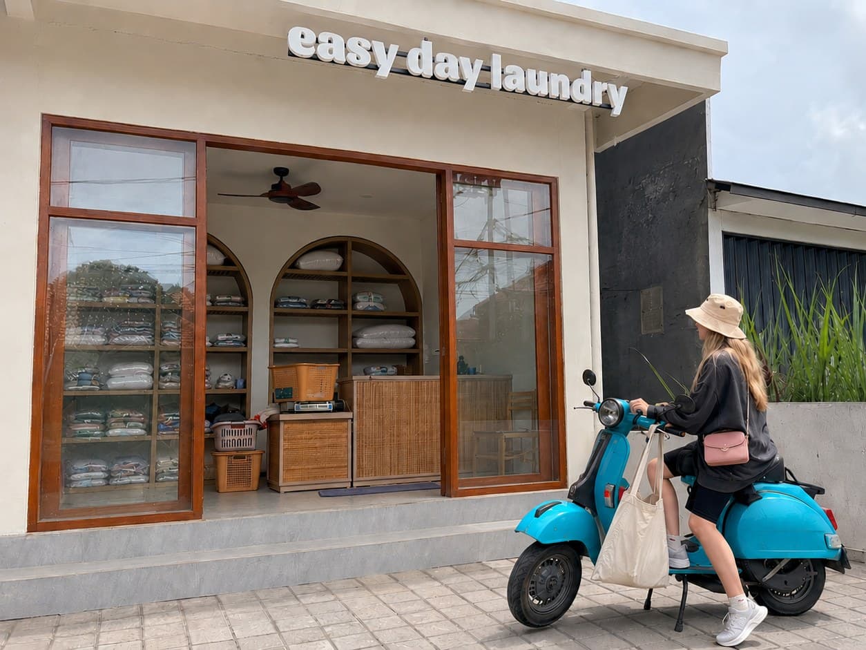 Easy Day Laundry 팀원이 외국인 거주자에게 주간 세탁 주문을 반환하는 모습